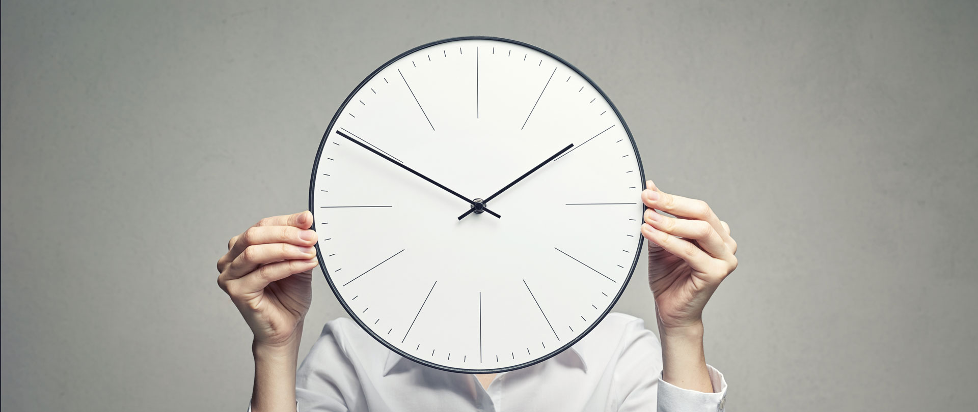 business woman covering her face with clock